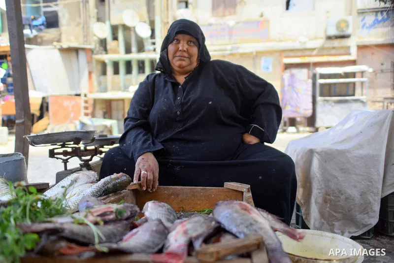An Egyptian woman displays fishes at her shop on the holy month of Ramadan at a fishes market at the Imbaba area in Cairo, Egypt, on June 11, 2016. Ramadan is sacred to Muslims because it is during that month that tradit...