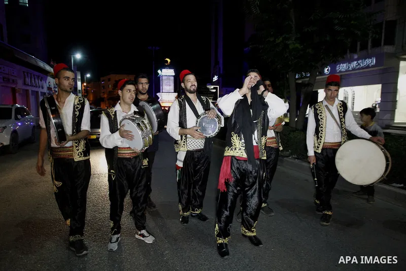 Palestinians dawn awakener "al-Musaharati" walk through streets to wake up Muslims for a meal before sunrise during the fasting month of Ramadan, in the West Bank city of Hebron city on June 12, 2016. Al-Musaharati is an...