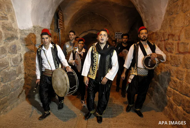 Palestinians dawn awakener "al-Musaharati" walk through streets to wake up Muslims for a meal before sunrise during the fasting month of Ramadan, in the West Bank city of Hebron city on June 12, 2016. Al-Musaharati is an...