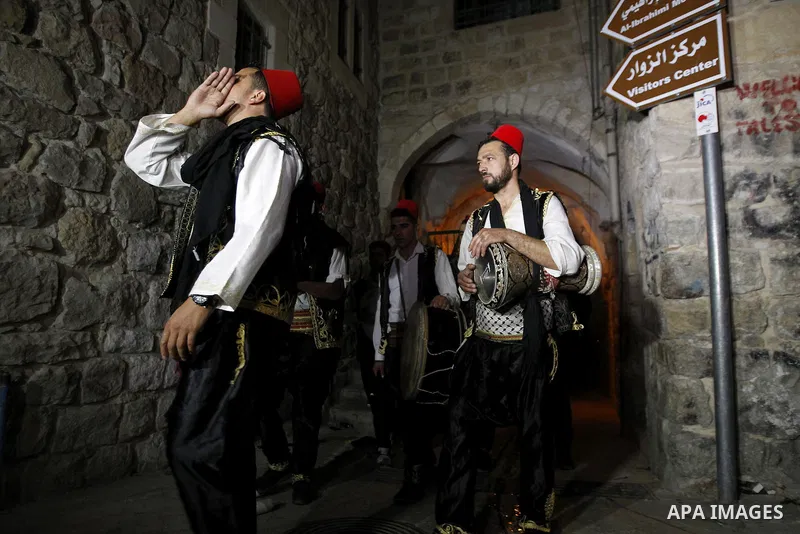 Palestinians dawn awakener "al-Musaharati" walk through streets to wake up Muslims for a meal before sunrise during the fasting month of Ramadan, in the West Bank city of Hebron city on June 12, 2016. Al-Musaharati is an...