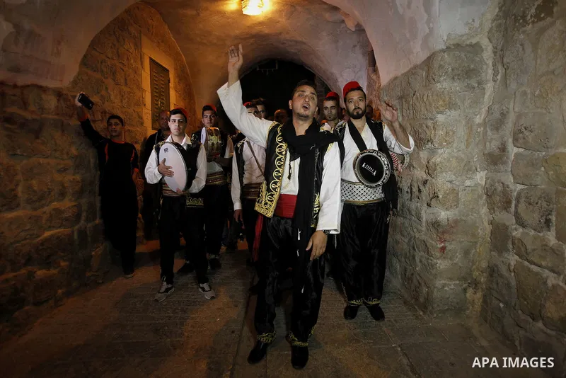 Palestinians dawn awakener "al-Musaharati" walk through streets to wake up Muslims for a meal before sunrise during the fasting month of Ramadan, in the West Bank city of Hebron city on June 12, 2016. Al-Musaharati is an...