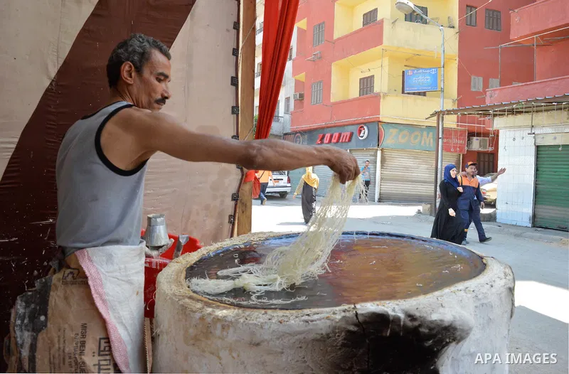 An Egyptian man prepares a traditional sweets "Konafa" on the holy month of Ramadan, in Cairo, Egypt, on June 12, 2016. Ramadan is sacred to Muslims because it is during that month that tradition says the Koran was revea...