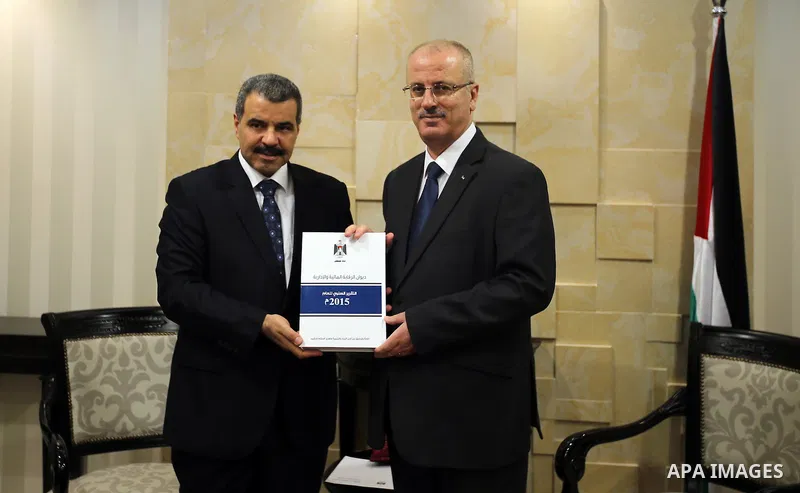 Palestinian Prime Minister Rami Hamdallah receives the Annual report of the Office of Financial and Administrative Control of 2015, in the West Bank city of Ramallah on June 12, 2016. Photo by Prime Minister Office