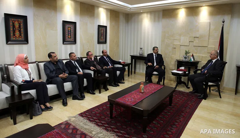 Palestinian Prime Minister Rami Hamdallah receives the Annual report of the Office of Financial and Administrative Control of 2015, in the West Bank city of Ramallah on June 12, 2016. Photo by Prime Minister Office