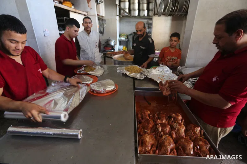 Palestinians prepare rice and meats as they wait for customers several hours before Iftar, the breaking of the day long Ramadan fast in Gaza City, on June 12, 2016. Muslims around the world refrain from eating, drinking...
