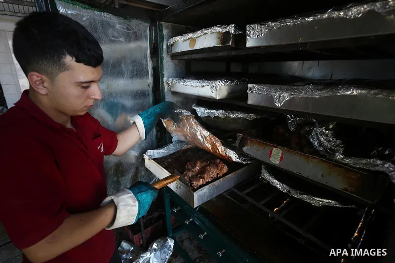 Palestinians prepare rice and meats as they wait for customers several hours before Iftar, the breaking of the day long Ramadan fast in Gaza City, on June 12, 2016. Muslims around the world refrain from eating, drinking...