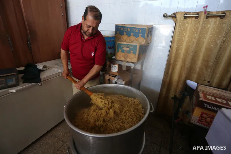 Palestinians prepare rice and meats as they wait for customers several hours before Iftar, the breaking of the day long Ramadan fast in Gaza City, on June 12, 2016. Muslims around the world refrain from eating, drinking...