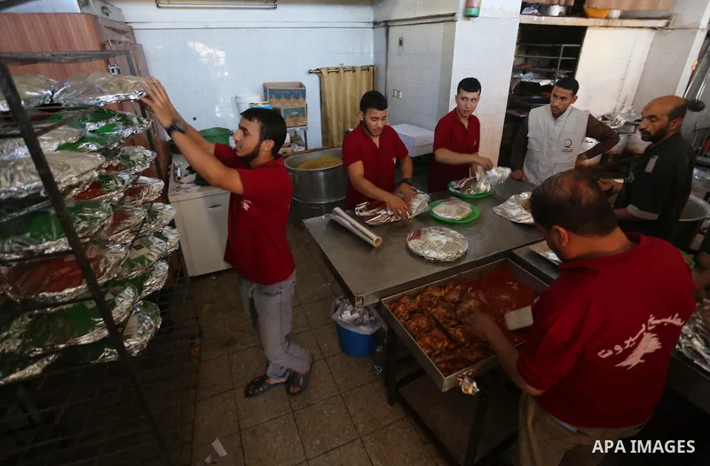 Palestinians prepare rice and meats as they wait for customers several hours before Iftar, the breaking of the day long Ramadan fast in Gaza City, on June 12, 2016. Muslims around the world refrain from eating, drinking...