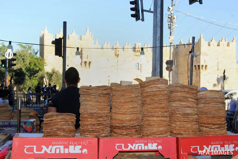 A Palestinian boy sells bread in front of Damascus gate during the Muslim holy fasting month of Ramadan in Jerusalem's old city on June, 12, 2016. Ramadan is sacred to Muslims because it is during that month that traditi...