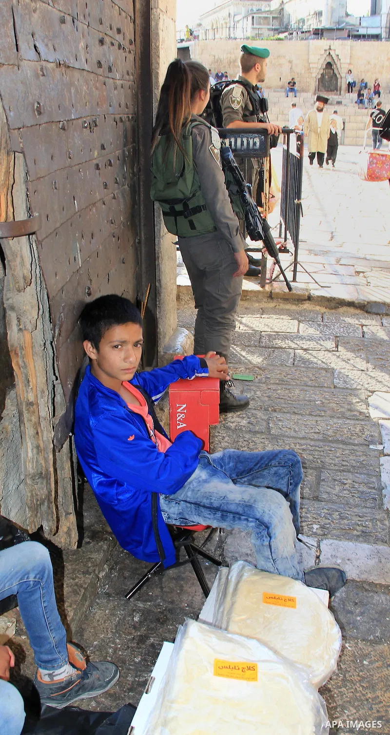 A Palestinian boy sells bread in front of Damascus gate during the Muslim holy fasting month of Ramadan in Jerusalem's old city on June, 12, 2016. Ramadan is sacred to Muslims because it is during that month that traditi...