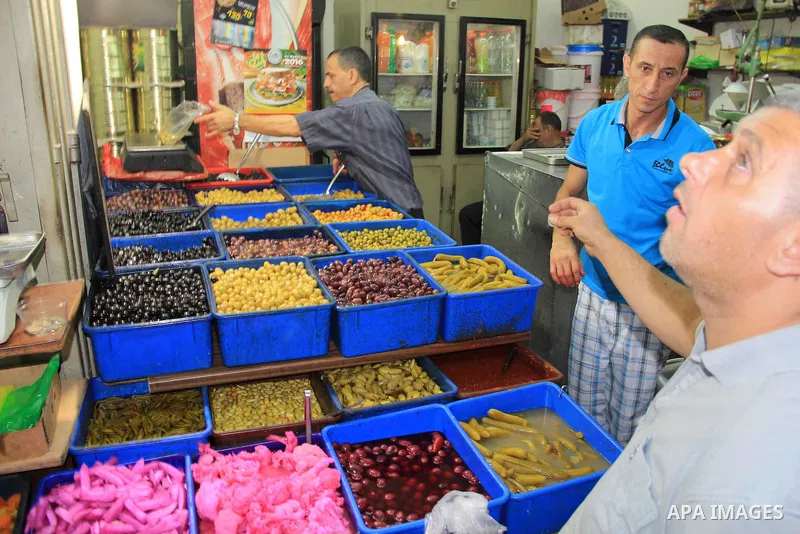A Palestinian man sells pickles at a market during the Muslim holy fasting month of Ramadan in Jerusalem's old city on June, 12, 2016. Ramadan is sacred to Muslims because it is during that month that tradition says the...