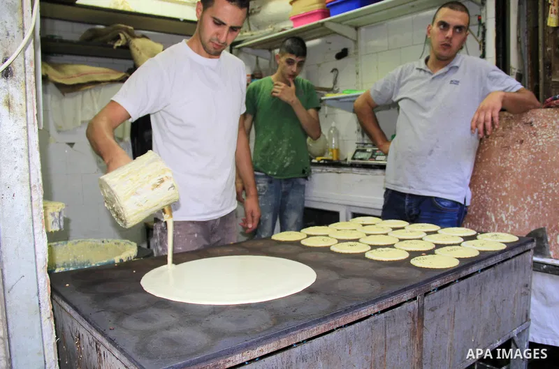 A Palestinian man prepares traditional pancakes known as ''Qatayef" at a market during the Muslim holy fasting month of Ramadan in Jerusalem's old city on June, 12, 2016. Ramadan is sacred to Muslims because it is during...