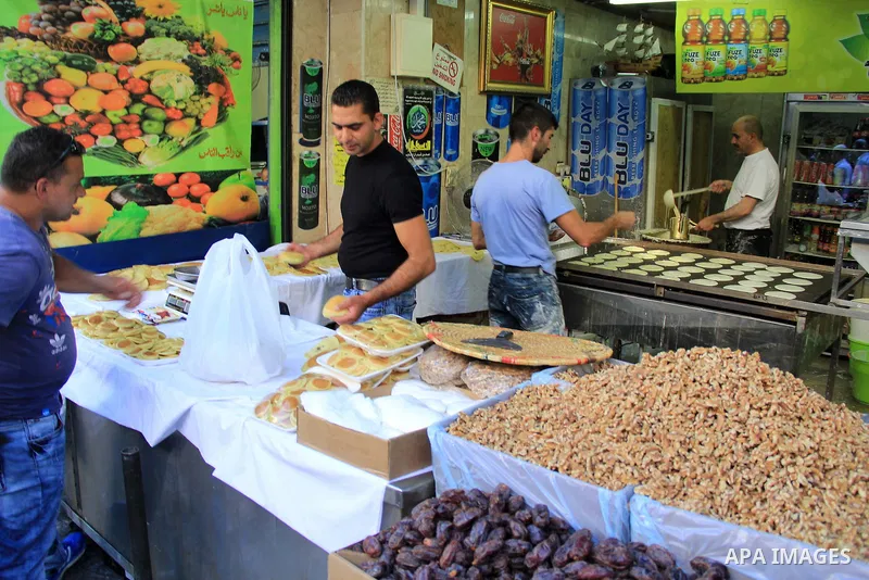 A Palestinian man prepares traditional pancakes known as ''Qatayef" at a market during the Muslim holy fasting month of Ramadan in Jerusalem's old city on June, 12, 2016. Ramadan is sacred to Muslims because it is during...