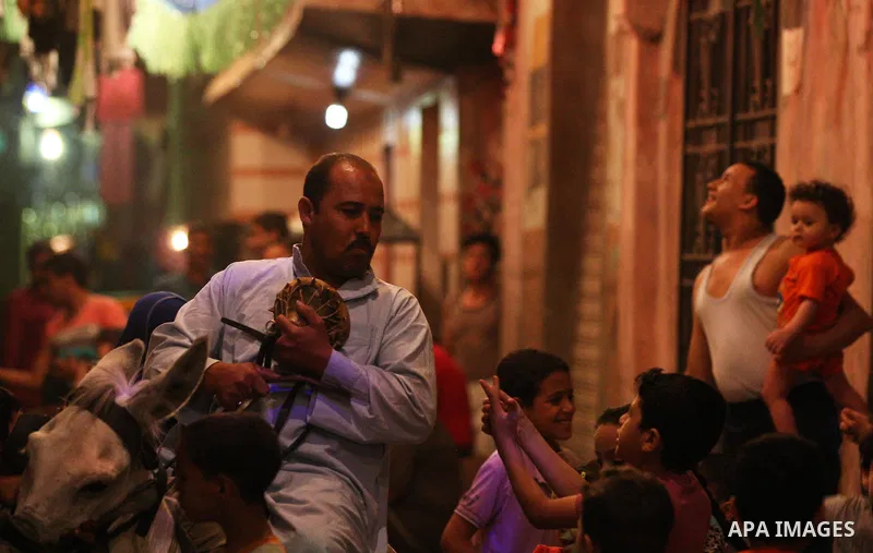 An Egyptian dawn awakener "al-Musaharati" ride a donkey through streets to wake up Muslims for a meal before sunrise during the fasting month of Ramadan, in Cairo, Egypt, on June 13, 2016. Al-Musaharati is an old profess...