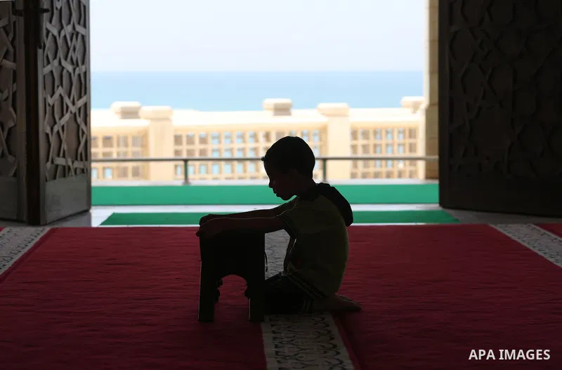 A Palestinian boy sits reading the Koran, Islam's holy book, at the al-Khaldi mosque during the Muslim fasting month of Ramadan, in Gaza City on June 13, 2016. Photo by Mohammed Asad