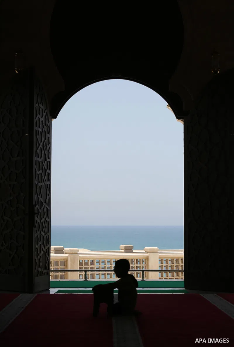 A Palestinian boy sits reading the Koran, Islam's holy book, at the al-Khaldi mosque during the Muslim fasting month of Ramadan, in Gaza City on June 13, 2016. Photo by Mohammed Asad