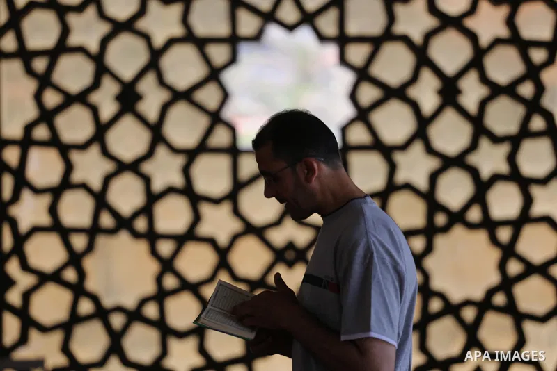 A Palestinian man sits reading the Koran, Islam's holy book, at the al-Khaldi mosque during the Muslim fasting month of Ramadan, in Gaza City on June 13, 2016. Photo by Mohammed Asad
