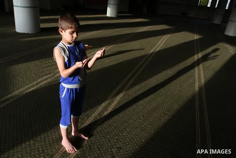 A Palestinian boy prays at the mosque during the Muslim fasting month of Ramadan, in Rafah in the southern Gaza strip on June 13, 2016. Photo by Abed Rahim Khatib