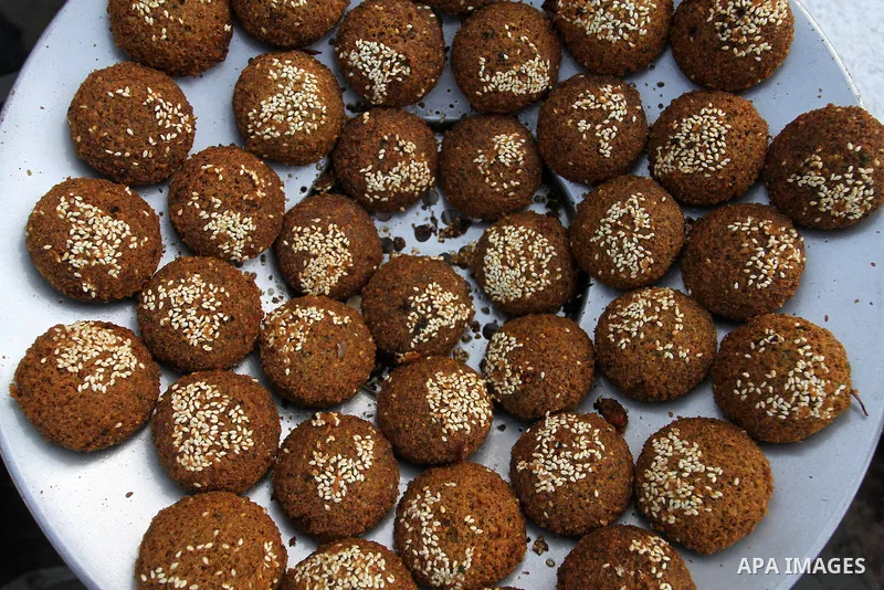 A Palestinian man prepares dishes of traditional chickpeas known as "Falafel" during the Muslim fasting month of Ramadan, in Rafah in the southern Gaza strip on June 13, 2016. Photo by Abed Rahim Khatib