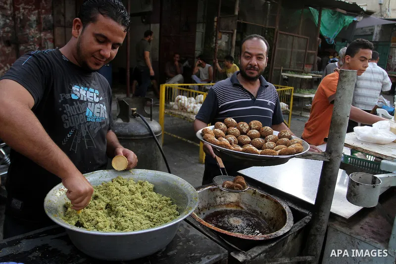 A Palestinian man prepares dishes of traditional chickpeas known as "Falafel" during the Muslim fasting month of Ramadan, in Rafah in the southern Gaza strip on June 13, 2016. Photo by Abed Rahim Khatib