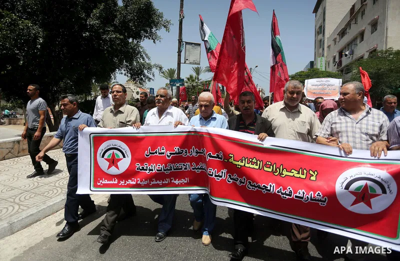 Palestinian supporters of the Democratic Front for the Liberation of Palestine (DFLP) shout slogans and hold banners during a demonstration to calling for an end in the political division and the national reconciliation,...