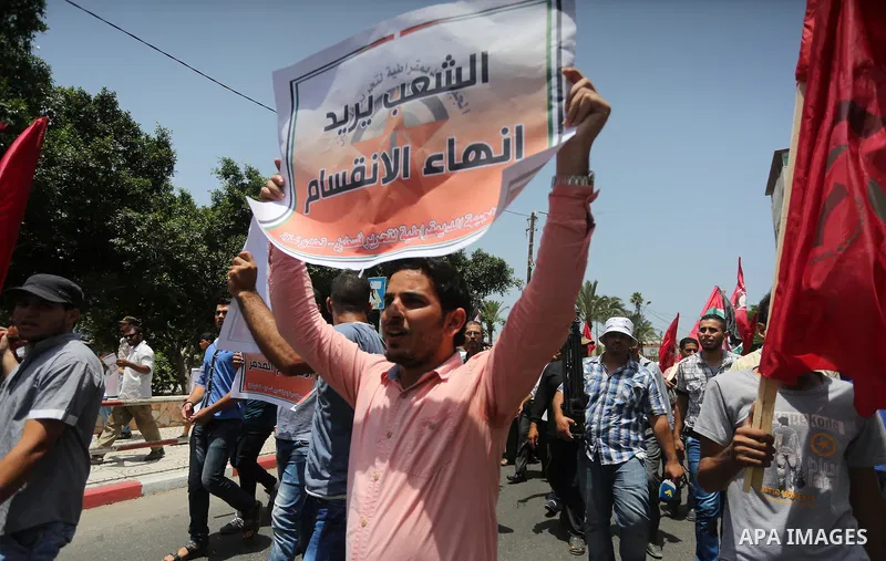 Palestinian supporters of the Democratic Front for the Liberation of Palestine (DFLP) shout slogans and hold banners during a demonstration to calling for an end in the political division and the national reconciliation,...
