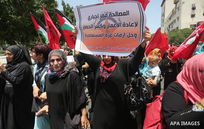 Palestinian supporters of the Democratic Front for the Liberation of Palestine (DFLP) shout slogans and hold banners during a demonstration to calling for an end in the political division and the national reconciliation,...