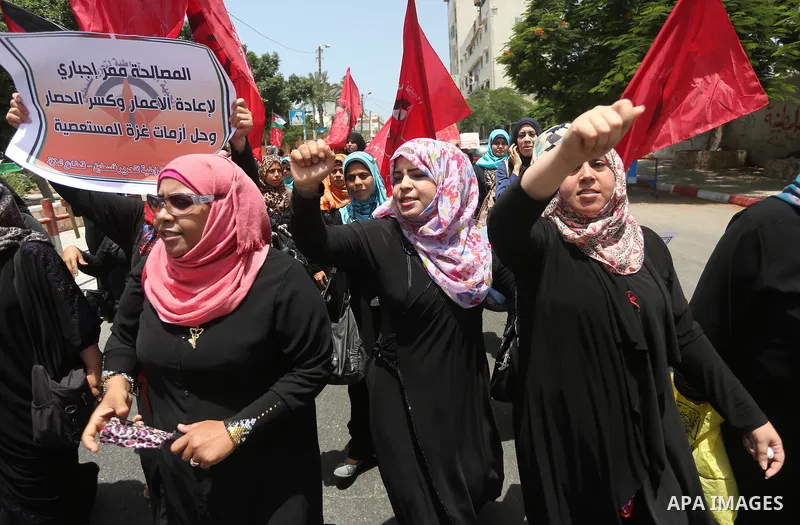 Palestinian supporters of the Democratic Front for the Liberation of Palestine (DFLP) shout slogans and hold banners during a demonstration to calling for an end in the political division and the national reconciliation,...