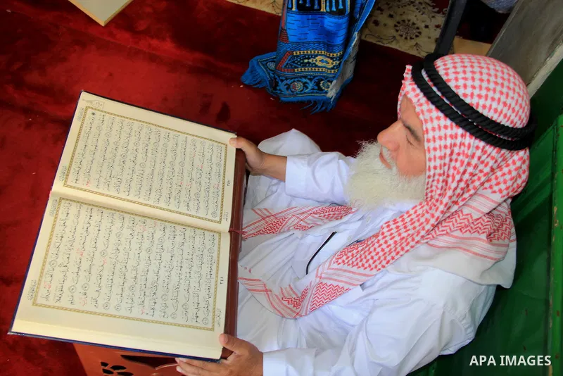 A Palestinian man reads the Koran, Islam's holy book, at al-Aqsa mosque during the holy month of Ramadan, in Jerusalem's old city on June 14, 2016. Ramadan is sacred to Muslims because it is during that month that tradit...