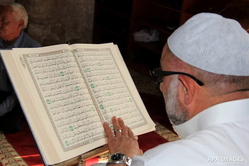 A Palestinian man reads the Koran, Islam's holy book, at al-Aqsa mosque during the holy month of Ramadan, in Jerusalem's old city on June 14, 2016. Ramadan is sacred to Muslims because it is during that month that tradit...