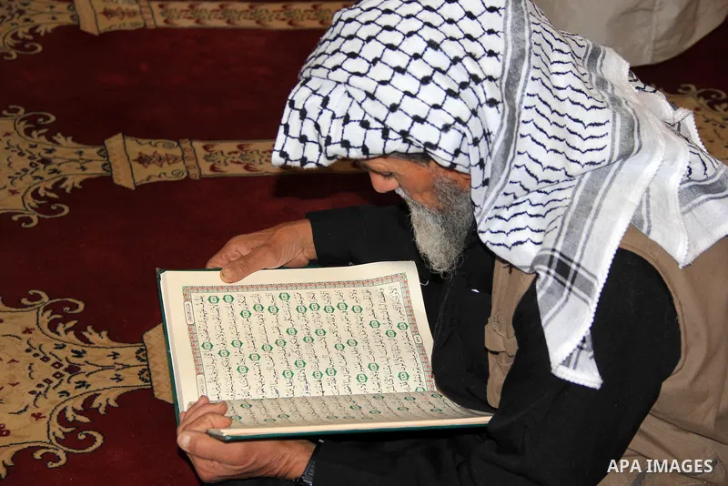 A Palestinian man reads the Koran, Islam's holy book, at al-Aqsa mosque during the holy month of Ramadan, in Jerusalem's old city on June 14, 2016. Ramadan is sacred to Muslims because it is during that month that tradit...