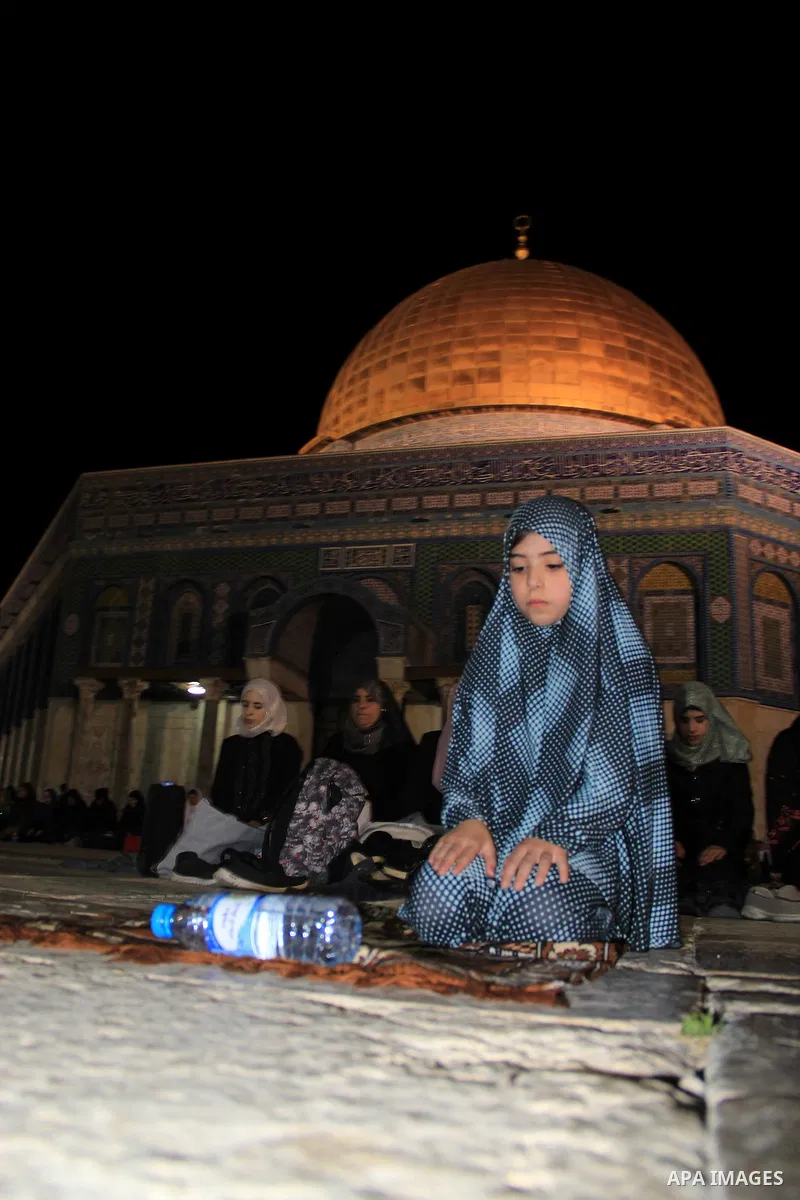 Palestinian women perform "Taraweeh", nightly prayer of the month of Ramadan, in front of the Dome of the Rock mosque, in Jerusalem's old city on June 14, 2016. Ramadan is sacred to Muslims because it is during that mont...