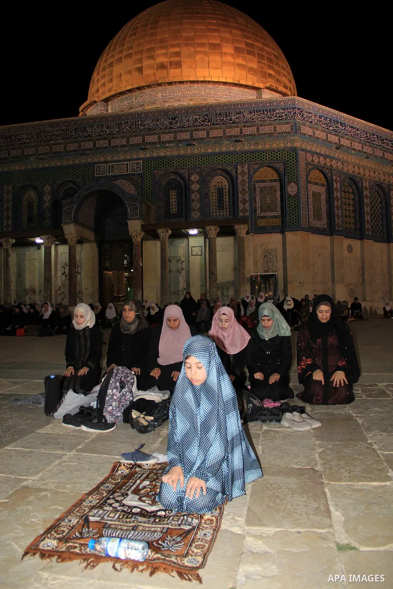 Palestinian women perform "Taraweeh", nightly prayer of the month of Ramadan, in front of the Dome of the Rock mosque, in Jerusalem's old city on June 14, 2016. Ramadan is sacred to Muslims because it is during that mont...
