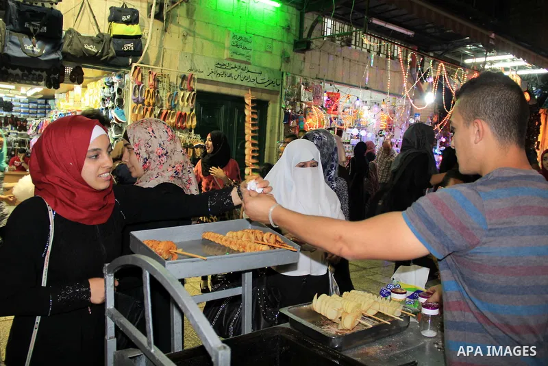 Palestinians shop at a market following "Taraweeh", nightly prayer of the month of Ramadan, at al-Aqsa mosque, in Jerusalem's old city on June 14, 2016. Ramadan is sacred to Muslims because it is during that month that t...