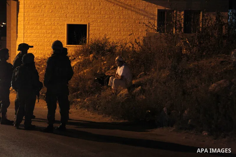 Israeli army soldiers stand guard during a searching and arresting in the West Bank village of Yatta June 15 2016. the Israeli army carry on a night after night military campaign in Yatta after 2 Palestinians attacked an...