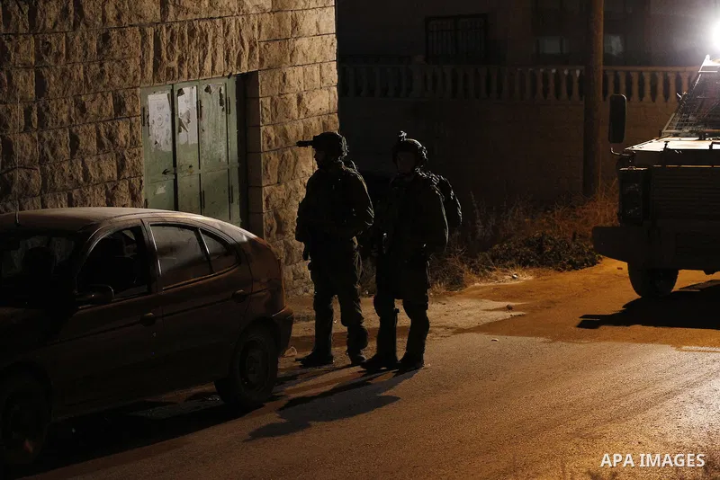 Israeli army soldiers stand guard during a searching and arresting in the West Bank village of Yatta June 15 2016. the Israeli army carry on a night after night military campaign in Yatta after 2 Palestinians attacked an...
