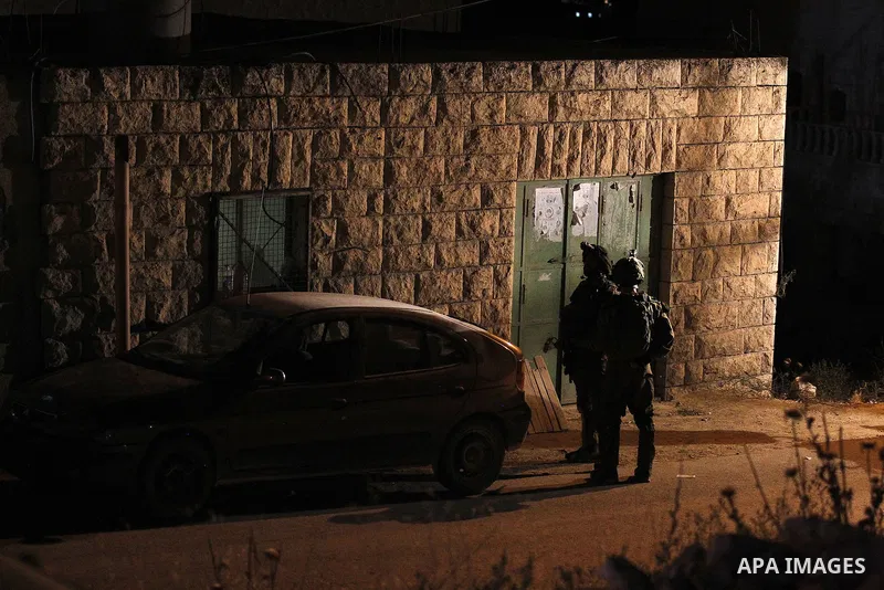 Israeli army soldiers stand guard during a searching and arresting in the West Bank village of Yatta June 15 2016. the Israeli army carry on a night after night military campaign in Yatta after 2 Palestinians attacked an...