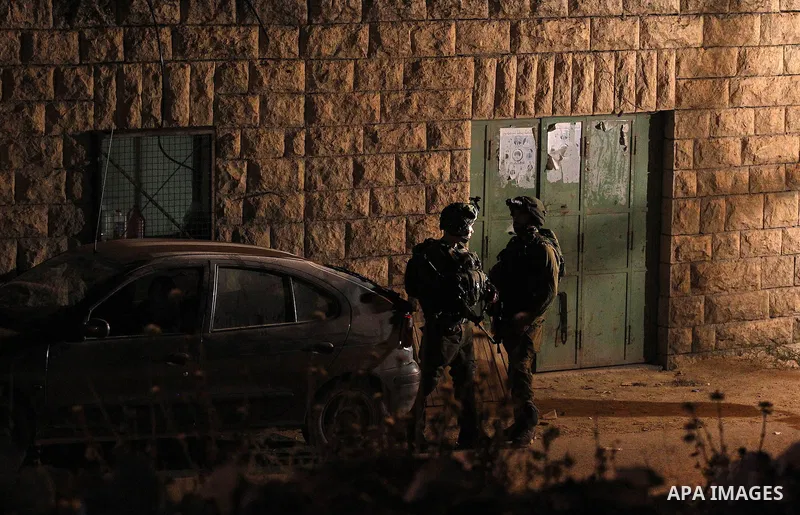 Israeli army soldiers stand guard during a searching and arresting in the West Bank village of Yatta June 15 2016. the Israeli army carry on a night after night military campaign in Yatta after 2 Palestinians attacked an...