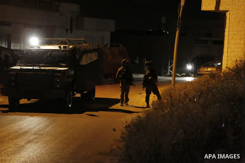 Israeli army soldiers stand guard during a searching and arresting in the West Bank village of Yatta June 15 2016. the Israeli army carry on a night after night military campaign in Yatta after 2 Palestinians attacked an...