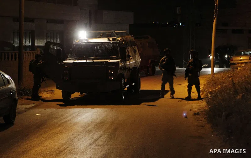 Israeli army soldiers stand guard during a searching and arresting in the West Bank village of Yatta June 15 2016. the Israeli army carry on a night after night military campaign in Yatta after 2 Palestinians attacked an...