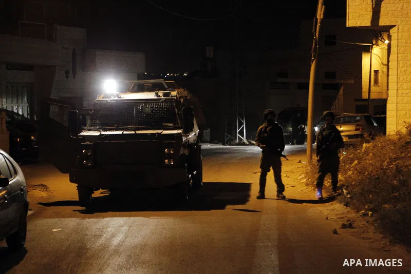 Israeli army soldiers stand guard during a searching and arresting in the West Bank village of Yatta June 15 2016. the Israeli army carry on a night after night military campaign in Yatta after 2 Palestinians attacked an...
