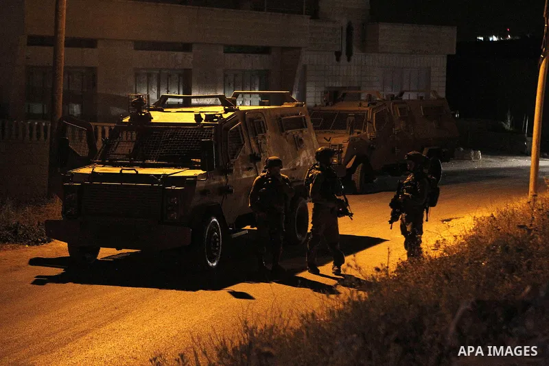 Israeli army soldiers stand guard during a searching and arresting in the West Bank village of Yatta June 15 2016. the Israeli army carry on a night after night military campaign in Yatta after 2 Palestinians attacked an...