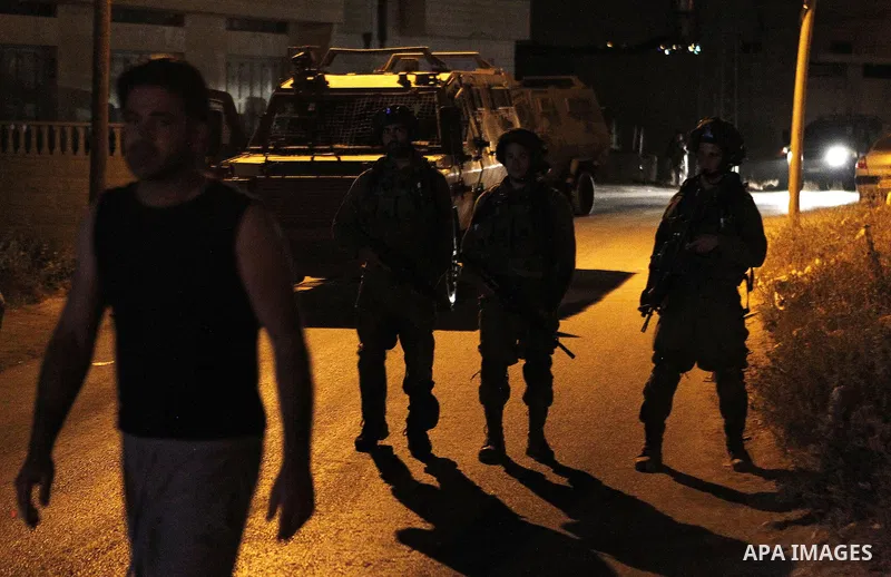 Israeli army soldiers stand guard during a searching and arresting in the West Bank village of Yatta June 15 2016. the Israeli army carry on a night after night military campaign in Yatta after 2 Palestinians attacked an...