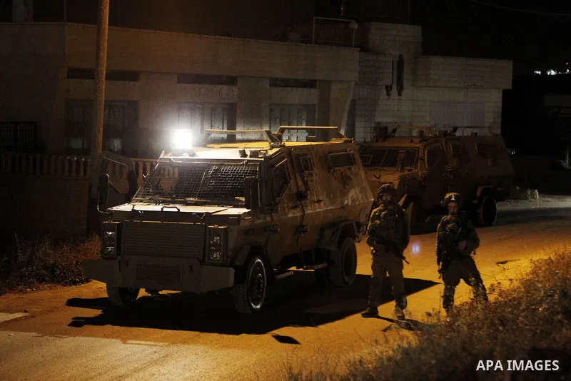 Israeli army soldiers stand guard during a searching and arresting in the West Bank village of Yatta June 15 2016. the Israeli army carry on a night after night military campaign in Yatta after 2 Palestinians attacked an...