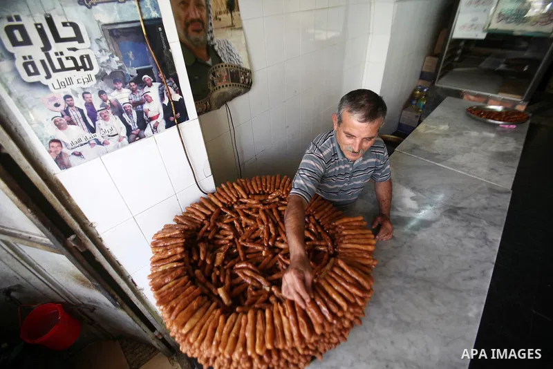 A Palestinian vendor prepares traditional sweets called "awwamah" at his shop at a market during the holy month of Ramadan in the West Bank city of Nablus, on June 15, 2016. Ramadan is sacred to Muslims because it is dur...