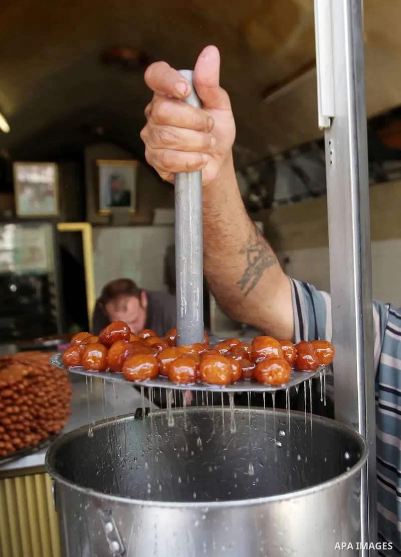 A Palestinian vendor prepares traditional sweets called "awwamah" at his shop at a market during the holy month of Ramadan in the West Bank city of Nablus, on June 15, 2016. Ramadan is sacred to Muslims because it is dur...
