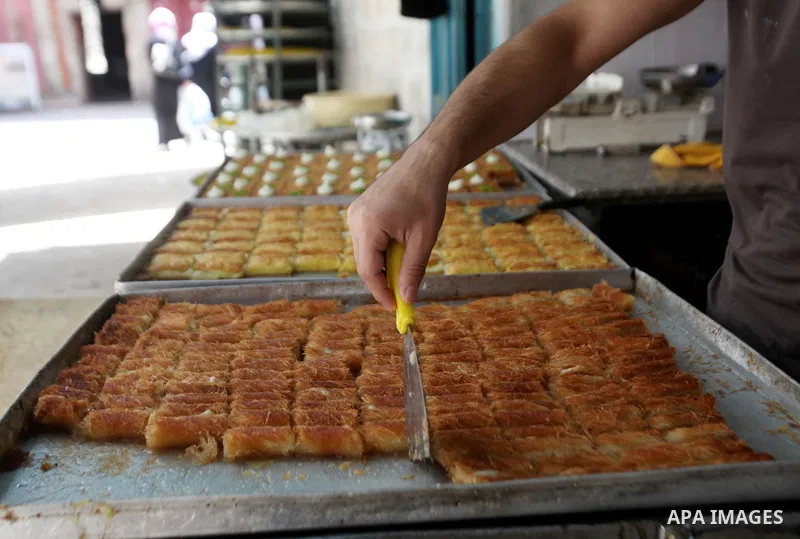 A Palestinian vendor prepares traditional sweets called "awwamah" at his shop at a market during the holy month of Ramadan in the West Bank city of Nablus, on June 15, 2016. Ramadan is sacred to Muslims because it is dur...