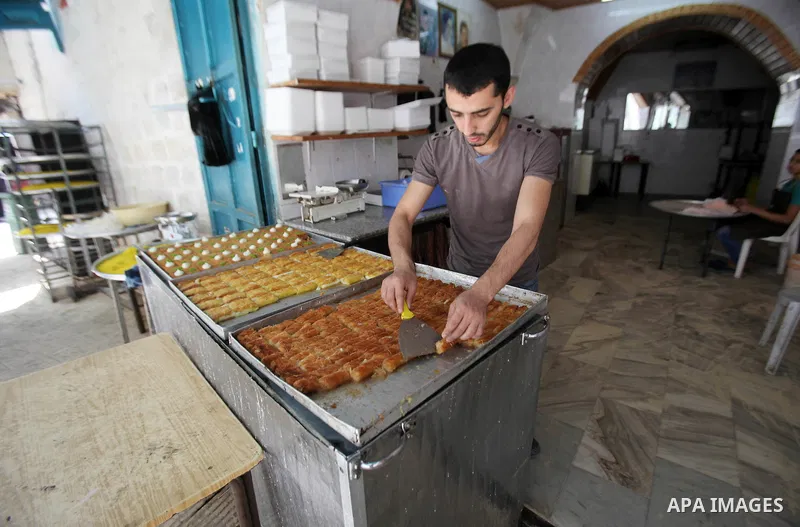 A Palestinian vendor sells sweets at his shop at a market during the holy month of Ramadan in the West Bank city of Nablus, on June 15, 2016. Ramadan is sacred to Muslims because it is during that month that tradition sa...