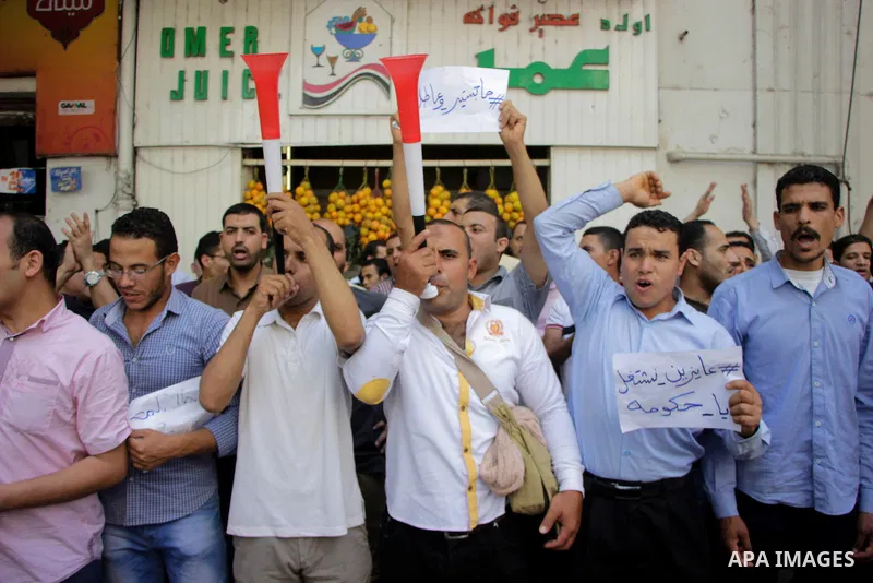 Egyptians Who obtained master's degree hold placards and shout slogans during a protest to demand jobs in Cairo, Egypt, on June 15, 2016. Photo by Amr Sayed