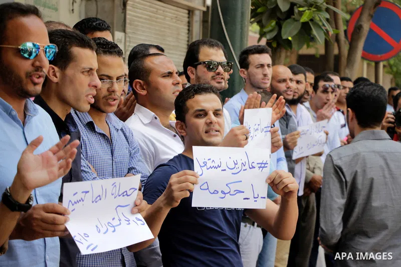 Egyptians Who obtained master's degree hold placards and shout slogans during a protest to demand jobs in Cairo, Egypt, on June 15, 2016. Photo by Amr Sayed